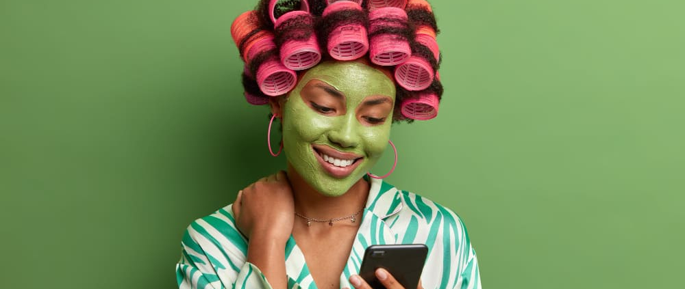 Una mujer en una peluquería ecológica sonriente porque además de ponerse guapa esta contribuyendo en una causa social.